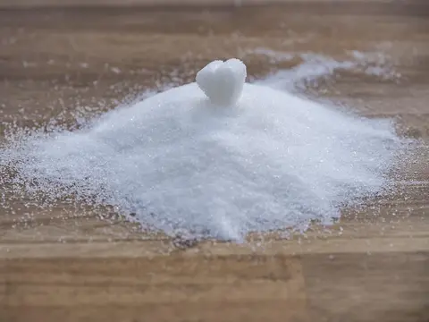 Montón de azúcar blanco sobre una mesa de madera