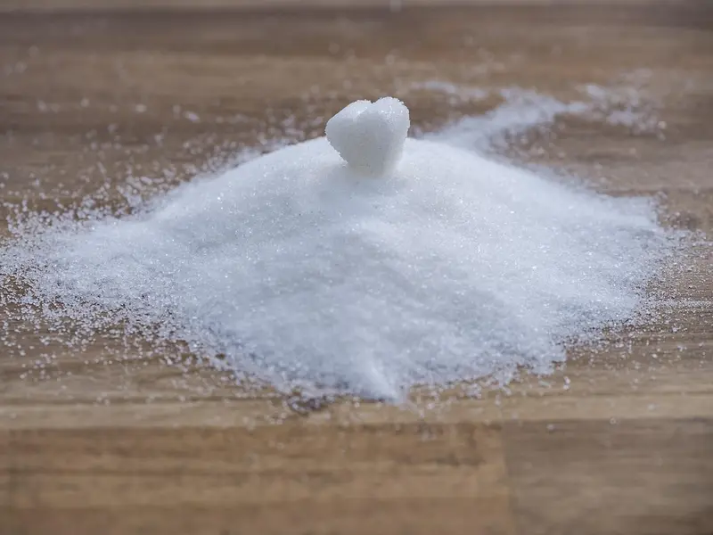 Montón de azúcar blanco sobre una mesa de madera
