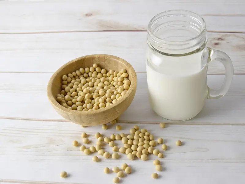 Vaso de bebida de soja junto a un cuenco de habas de soja