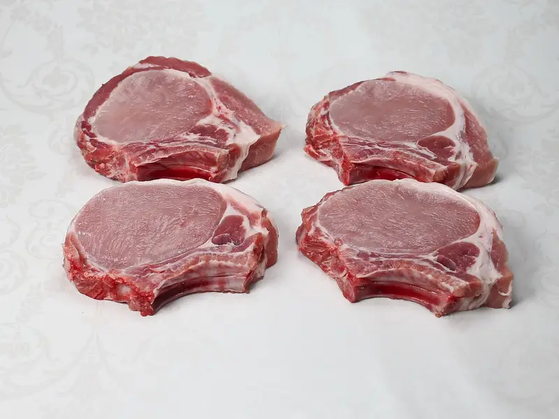 Cuatro chuletas de cerdo crudas