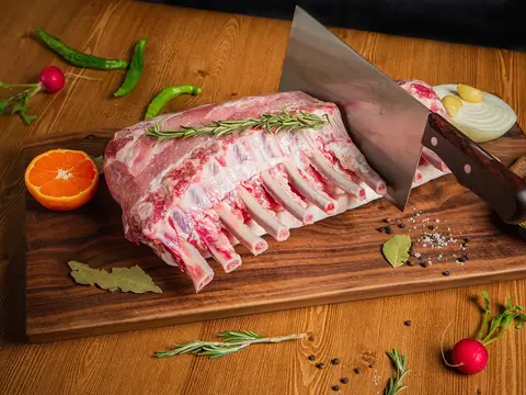 Costillar de cordero crudo sobre una tabla