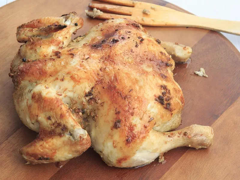 Pollo entero asado sobre una tabla