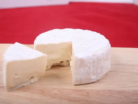 Queso brie entero con una cuña cortada