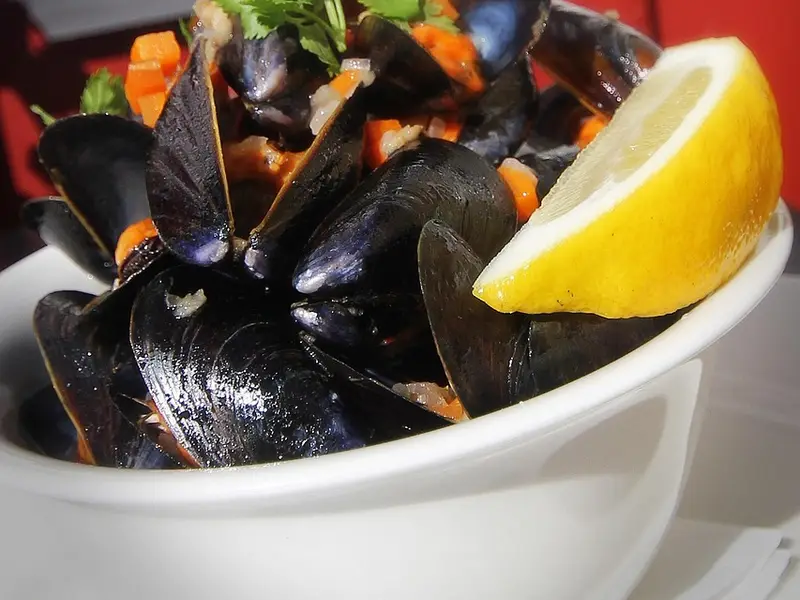 Mejillones al vapor en un cuenco con una rodaja de limón